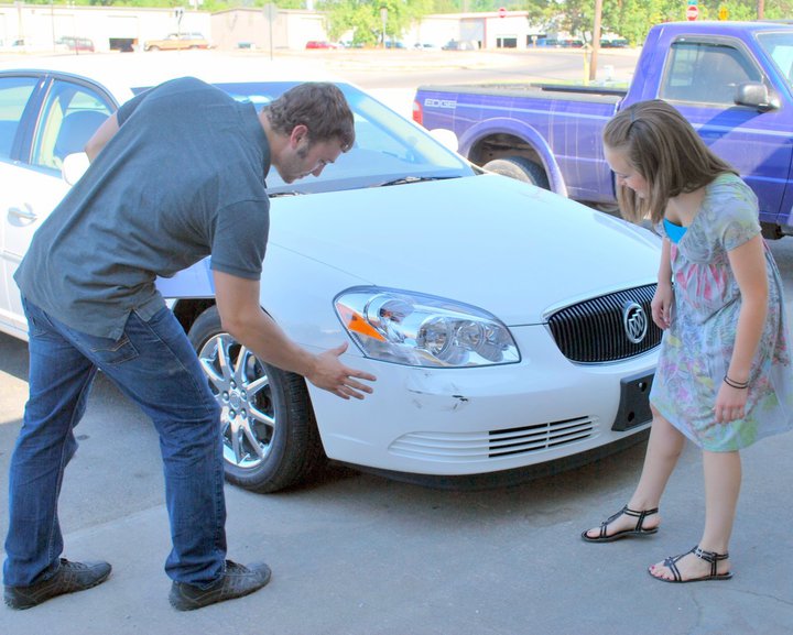 People Looking at Car Dent